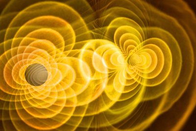 Wissenschaftliche Simulation des Verschmelzens zweier Schwarzer Löcher. Die ringartigen gelben Strukturen zeigen an, wie Schwerkraftfelder dabei interagieren.