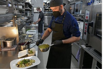 In der Küche der Stadtwirtschaft stellt Sous Chef Alexander Schubert ein Essen to go zusammen: hausgemachte Ziegenpelmeni mit Roter Beete, Thymianhonig und Walnüssen.