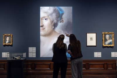 Blick in die Ausstellung "Rosalba Carriera. Perfektion in Pastell" in der Gemäldegalerie Alte Meister im Zwinger in Dresden. Zu sehen ist hier ein vergrößerter Ausschnitt eines Selbstbildnisses von Rosalba Carriera - ohne Idealisierung mit Spuren des Alters drückt es Weisheit und Selbstbewusstsein aus. 