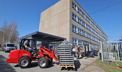 Mit Gabelstaplern werden die Paletten mit den Metallbetten an das ehemalige Lehrlingswohnheim transportiert.