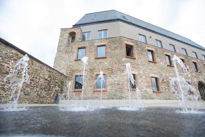 Der neue Hörsaal Audimax der Dualen Hochschule auf dem Schlossberg ist Teil der sanierten Schlossanlage, davor gibt es einen Springbrunnen.