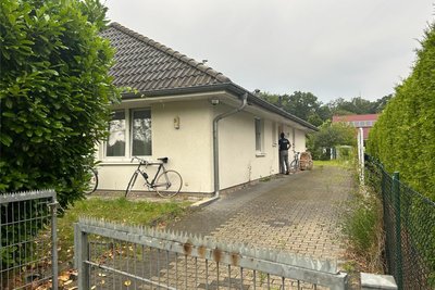 Falkensee am Dienstagmorgen: Ein Polizist steht vor der Tür eines Hauses. Die Polizei hat in Brandenburg Räumlichkeiten durchsucht, die dem vom Bundesamt für Verfassungsschutz als rechtsextremistisch eingestuften „Compact“-Magazin zugeordnet werden.