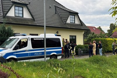 Magdeburg (Sachsen-Anhalt): Polizisten stehen am Dienstag vor einem Einfamilienhaus auf der Straße.