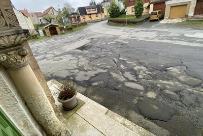 Zur engen Straße kommt noch ein Fußweg dazu. Dass gebaut wird, daran gibt es keinen Zweifel. Der Zustand von Platz und Fahrbahn ist marode.