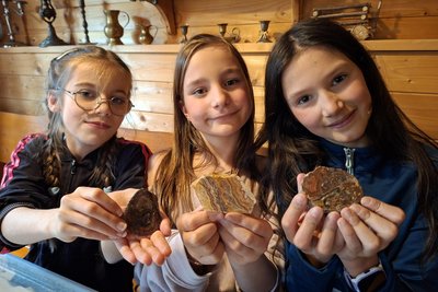 Greta, Lisa und Tilda (v.l.) zeigen die von ihnen geschliffenen Steine im Ferienhof Falkenau.