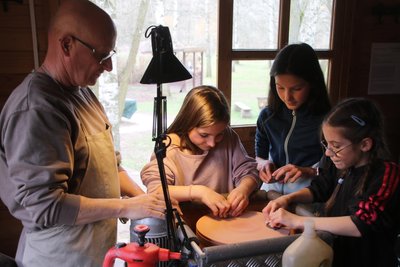 Spezialist Uwe Thonfeld zeigt Lisa, Tilda und Grete (v.l.) im Ferienhof Falkenau wie das Steineschleifen funktioniert.