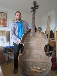 Stefan Rehms in seiner Werkstatt mit dem Kontrabass im Altzustand ohne Decke.