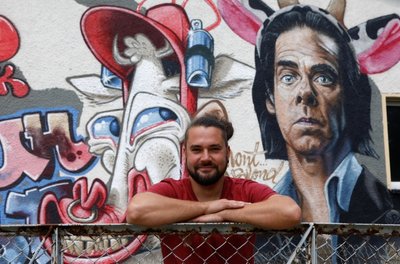 Tobias Winkler, Vorsitzender des Blinklicht-Vereins, an der mit Graffiti neugestalteten Fassade des Domizils an der Pappelstraße in Niederlungwitz. 