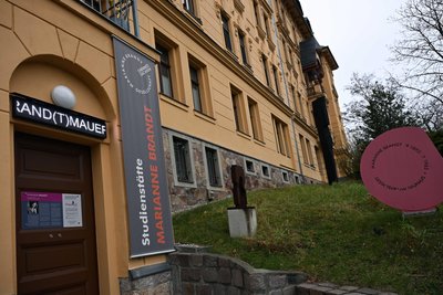 Eine Leuchtschrift am Marianne-Brandt-Haus nimmt auch zu aktuellen Problemen Stellung, setzt eine „Brand(t)mauer“ gegen Rechts. Foto: Matthias Zwarg