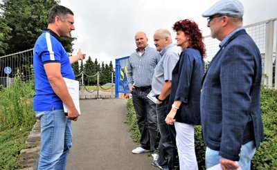 Ronny Röder (links), Vereinsvorsitzender des SV Coschütz, zeigt Frank Bilz vom Leader-Regionalmanagement und der Vorsitzenden der Lokalen Aktionsgruppe, Andrea Jedzig, die Fläche, auf der die Tafel aufgestellt werden soll. Am Ende des Weges entsteht gerade die neue Begegnungsstätte für den Ort. Mit im Bild: Sandro Bauroth (rechts), Bürgermeister von Elsterberg und Ortsvorsteher Andreas Oberlein (Mitte). 