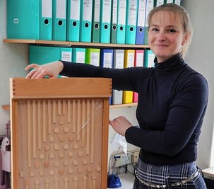 Linkes Bild: Heike Götze (li.) und Daniela Uhlig in den Räumen der kleinen Firma Reinhold in St. Egidien. Rechtes Bild: Peggy Höhne mit einem Galtonbrett: Wenn die Holzkugeln durch den Apparat rollen, bilden sie unten eine Gauß'sche Kurve. 