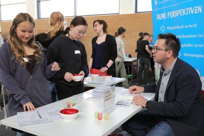Lana (links) und Marie am Stand eines Pflegeheimes. Sie mussten farbige Kugeln, die symbolisch für Tabletten standen, nach einem Medikamentenplan sortieren.