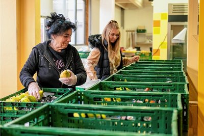 Helferin Annelie Ranft (vorn) und Tafelkoordinatorin Maxi Lippmann beim Packen von Lebensmittelkisten.