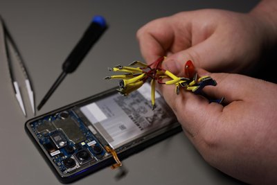Mit verschiedenen Gerätschaften findet er die Probleme der Handys heraus.