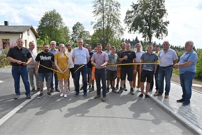 Am Mittwoch wurde die sanierte Bahnhofstraße in Schöneck von Bürgermeister Andy Anders (Mitte) wieder für den Verkehr freigegeben.