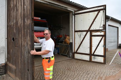 Bauhofmitarbeiter und Ortswehrleiter Rico Fuhrmann an einem der alten Tore am neuen Bauhof-Standort. Die Tore werden erneuert, wenn die Feuerwehr nach dem Umbau des Depots wieder dorthin zurückgezogen ist.