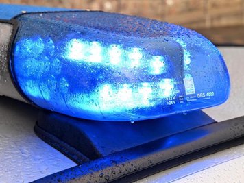  
          Ein Streifenwagen der Polizei mit eingeschaltetem Blaulicht.