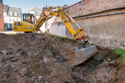 Die obersten Erdschichten werden mit schwerer Technik abgetragen.