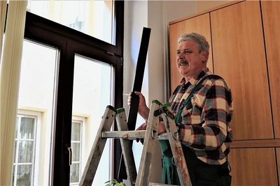 Guntram Bauer von der gleichnamigen Crimmitschauer Fensterbaufirma beim Anbringen der Leisten mit dem rutschigen Untergrund, die am oberen Teil der Rathausfenster fixiert werden. 