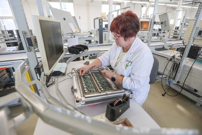 Mandy Seidel, Mitarbeiterin bei Aconnic, bestückt Leiterplatten.