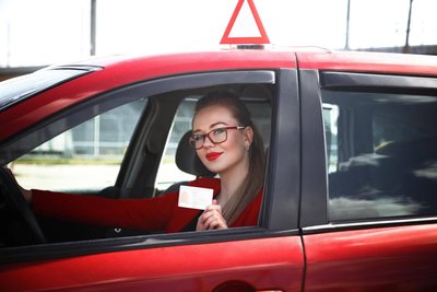 Eine junge Fahrschülerin zeigt ihren neuerworbenen Führerschein. Die EU hat jetzt die Regeln vereinheitlicht.