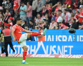 Phillipp Mwene schießt einen aufs Feld geworfenen Tennisball zurück Richtung Tribüne.