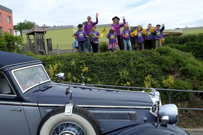 Mädchen und Jungen der Kita „August Horch“ winken den Oldtimer-Fahrern bei der Einfahrt in den Hof der einstigen Horch-Fabrik Reichenbach.