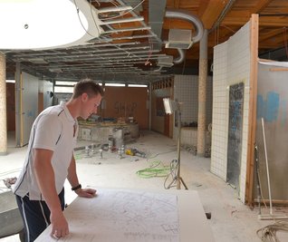 Baustelle im Johannisbad: Schwimmmeister Eric Hofmann vor den Sauna-Plänen, rechts Dampfbad, dahinter Durchgang zum Anbau.