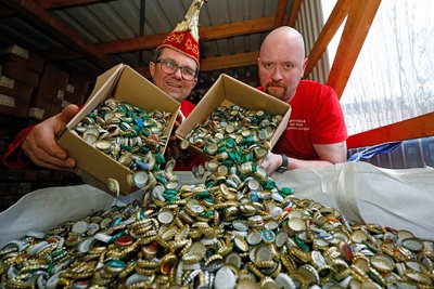 Uwe Liebschner (li.) und Daniel Steege schütten Kronkorken aus Kartons in einem großen "Bigpack".