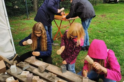 Kinder können aus Steinen Teelichthalter klopfen.