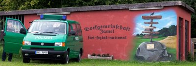Im völkisch-rechten Refugium: Eine Garagenwand in Jamel gibt Zufallsbesuchern deutlich Bescheid, wohin es sie verschlagen hat. Ein Pfeil am Originalwegweiser deutet auf Hitlers Geburtsort.