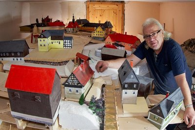 Künstler Jens Weber arbeitet am versunkenen Dorf Pöhl als Miniaturausgabe. Schloss, Kirche, Schule, Gasthof und andere zentrale Gebäude (hinten) stehen schon. Doch in seinem Haus stößt er jetzt an Grenzen. 