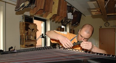 
              <p class="artikelinhalt">Steffen Meinel von der Horst Wünsche Zitherbau KG Markneukirchen beim Einsetzen der Reglerplatine einer E-Zither. </p>
            