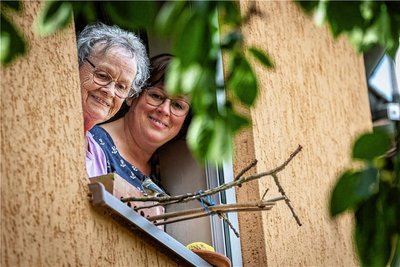 Gudrun Rost füttert gemeinsam mit ihrer Tochter Evelyn Pilz eine junge Blaumeise am Fenster ihrer Wohnung. Die beiden Frauen hatten seit Pfingsten drei Blaumeisen aufgezogen.