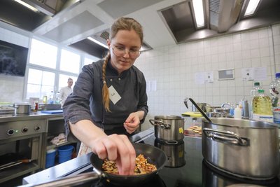 Melanie Wagner bereitet hier Apfel-Parmesanchips in einer Pfanne zu.