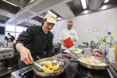 Martin Graf, Azubi im Hotel an der Oper, bereitet Polenta in einer Pfanne zu und wird von Sebastian Ehmke, Vorsitzender des Vereins Chemnitzer Köche, beobachtet.