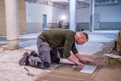 Im Garderobenbereich in der unteren Etage werden derzeit die Bodenfliesen verlegt.