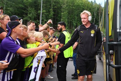 Julian Brandt klatscht vor dem Spiel wartende Fans ab.