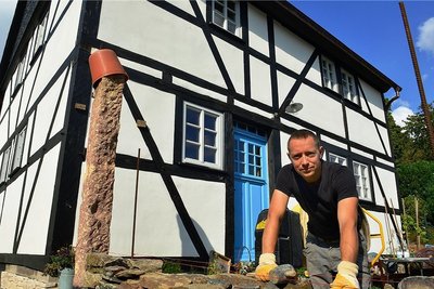 September 2021: Tony Wagner vor dem Fachwerkhaus am Rahmenberg in Hainichen. Derzeit arbeitet er noch an einer Bruchsteinmauer. Für die Sanierung gab es nun den Denkmalpreis des Landkreises. 