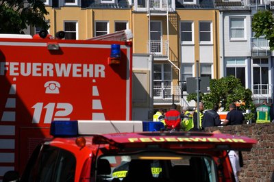 Rettungswagen, Polizisten und Polizeifahrzeuge stehen in der Nähe des Einsatzortes.