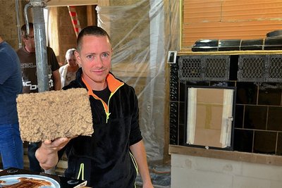 September 2019: Tony Wagner zeigt auf der Baustelle die Lehmziegel.