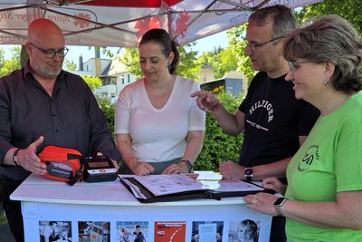 Miro Drechsel demonstriert den Defibrillator vor den Stiftungsräten Julia Gründig, Wolfgang Kern und Doreen Scholz .
