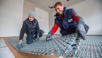 Raik Friedrich (l.) und Mike Rosenhahn von der Klempnerei Polusik aus Aue verlegen Wabenträgerplatten für die Fußbodenheizung.