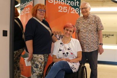 Angela und Rüdiger Schoppe mit Marina Eichhorn vorm Plakat mit dem „Faust“-Motto zur neuen Spielzeit.