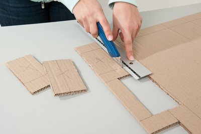 Die Basis fürs Wohnzimmer-Stadion: Aus einem Kartonstück entstehen Spielfeld, Banden und Tore – am besten mit Cuttermesser und Metalllineal.