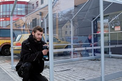Jeremy Heidelmann von der Shopbox Group Staßfurt beim Montieren der Einkaufswagen-Überdachung.
