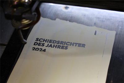 Mit dem Laser wird die Edelstahl-Banderole bearbeitet, die den Pokal einfasst.