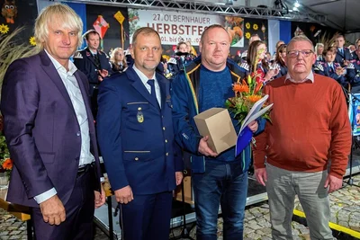 André Heinrich (2. v. r.) bekam von Olbernhaus Bürgermeister Jörg Klaffenbach (links) das Lebensrettungsehrenzeichen überreicht. Bei der Übergabe beim Herbstfest mit dabei waren Haselbachs Ortsvorsteher Thomas Böttcher (rechts) und Andreas Felgner vom Polizeirevier Freiberg.