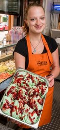 Eisdielerei-Mitarbeiterin Jennifer Salzmann zeigt eine Schale des grün-roten Olbernhauer 7-Täler-Eises. 