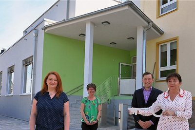 Bürgermeisterin Kerstin Nicolaus bei einer symbolischen Schlüsselübergabe mit ihrem 2. Stellvertreter Christfried Nicolaus, Schulleiterin Angela Müller und Kita-Leiterin Kristin Forner (l.) vor dem neuen Anbau. 